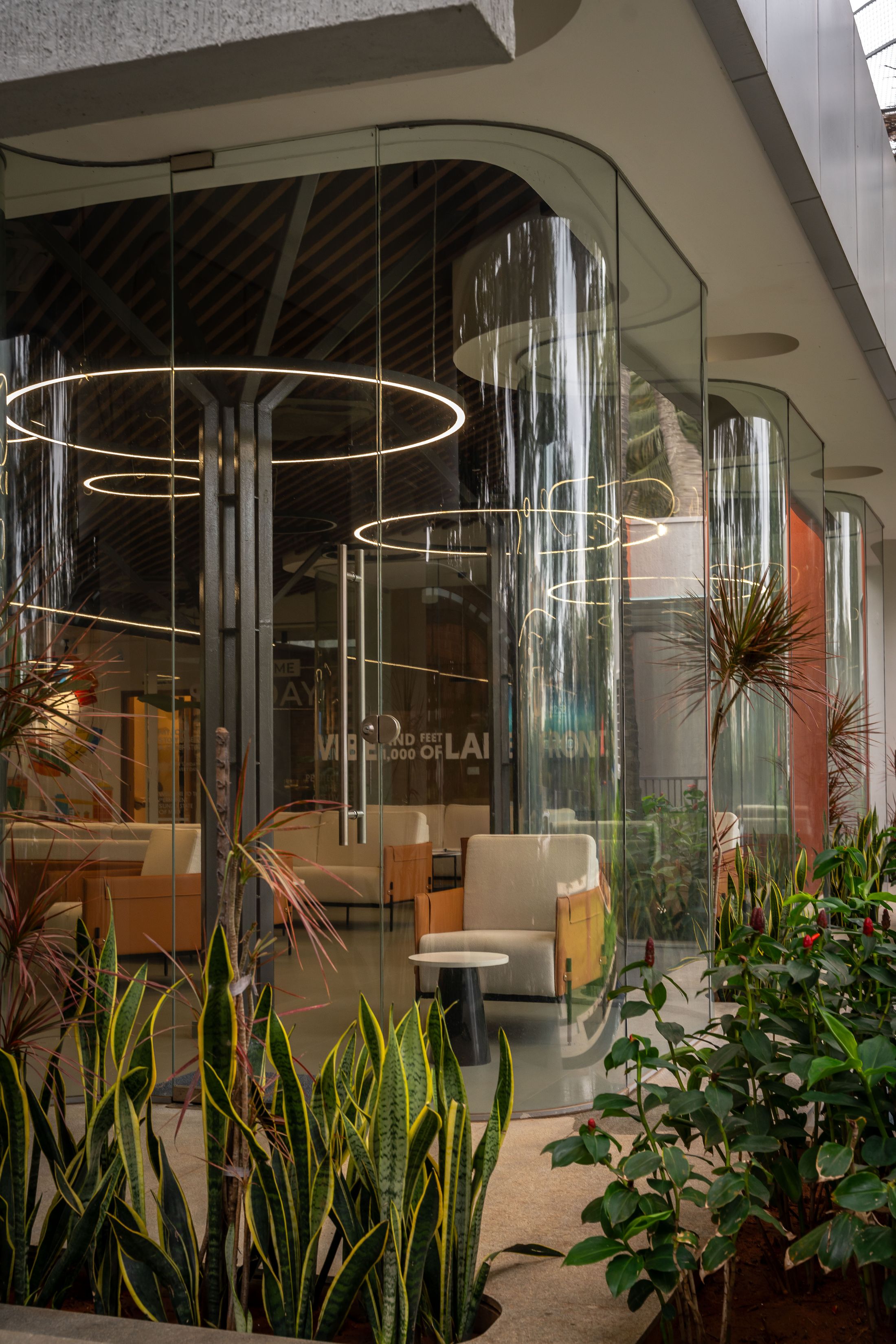 Glass architectural pavilion with a reflection pool at dusk, designed by UDAIN'S Interiors | Architecture