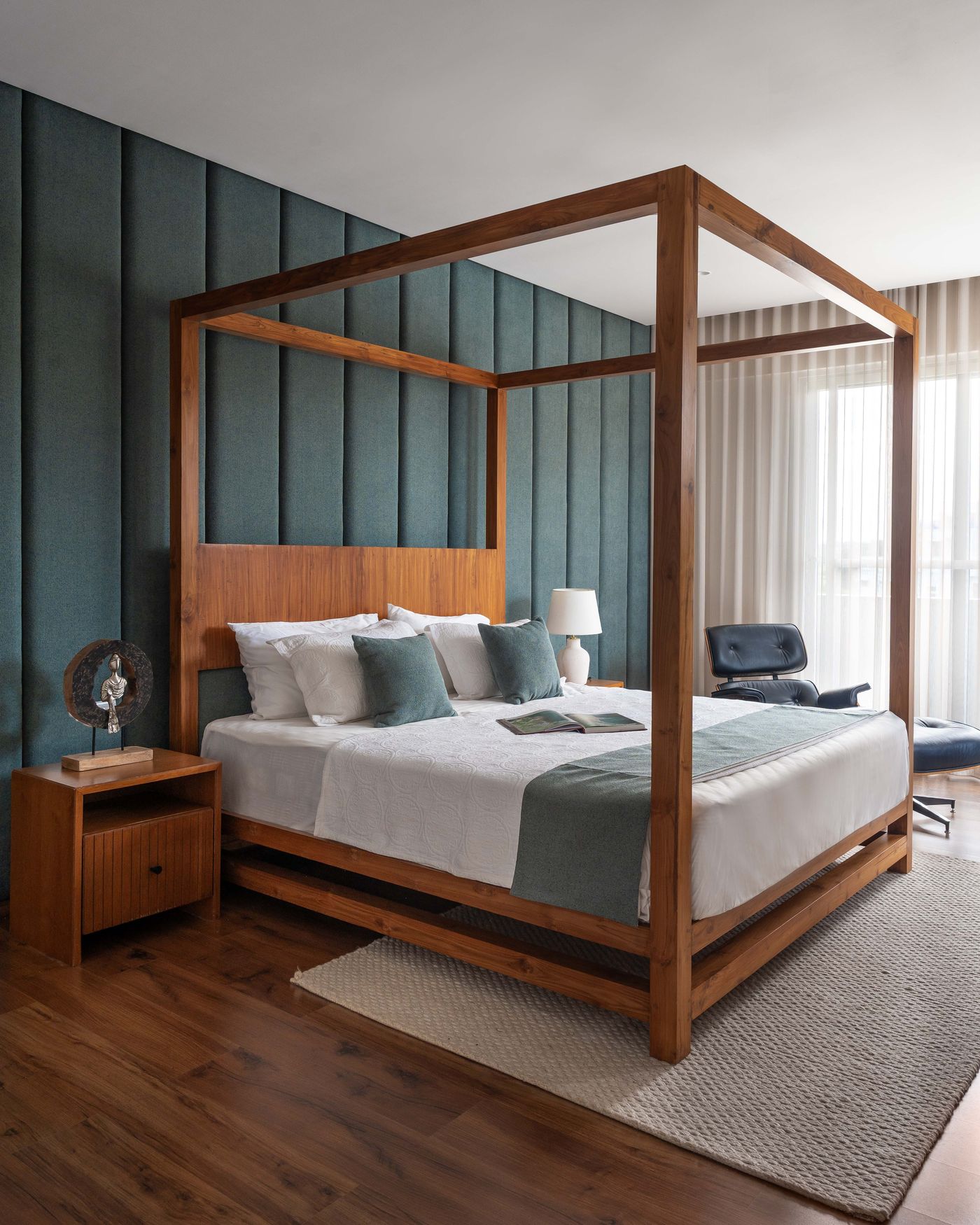 Four-poster wooden bed against a teal panelled wall, Saffron Skies residence