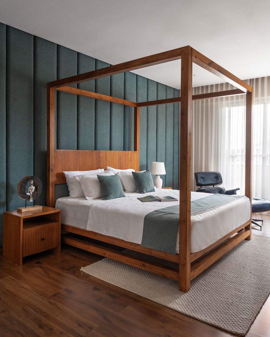 Four-poster wooden bed against a teal panelled wall, Saffron Skies residence