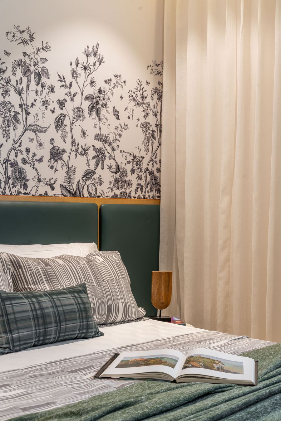 Bedroom bed detail with floral wallpaper